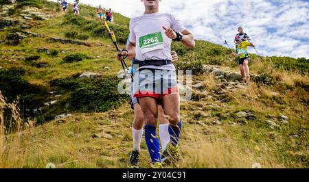 atleti di gruppo che corrono su una discesa ripida in una maratona di montagna Foto Stock