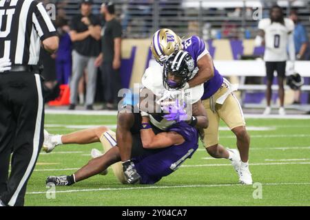 Seattle, Stati Uniti. 31 agosto 2024. Il running back dei Weber State Wildcats Adrian Cormier (2) viene affrontato dalla safety dei Washington Huskies Vincent Holmes (27) nel quarto quarto quarto di una partita di football universitario all'Husky Stadium di Seattle, Washington, il 31 agosto 2024. (Credito fotografico Nate Koppelman/Sipa USA) credito: SIPA USA/Alamy Live News Foto Stock