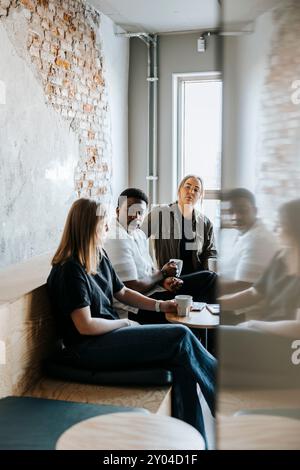 Imprenditori tecnologici uomini e donne discutono mentre bevono un caffè in ufficio Foto Stock