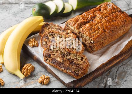 Pane alla banana con zucchine senza glutine appena sfornate con noci e cioccolato fondente primo piano su tavola di legno. Orizzontale Foto Stock