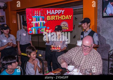 Il ragazzo di 9 anni (cambogiano-americano) festeggia il suo nono compleanno, il micro birrificio Tawandang, Phnom Penh, Cambogia. © Kraig Lieb Foto Stock