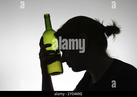 Bevande alcoliche donna di silhouette con una bottiglia di vino Foto Stock