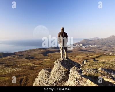 L'uomo sulla cima della montagna guardando la luna piena Foto Stock