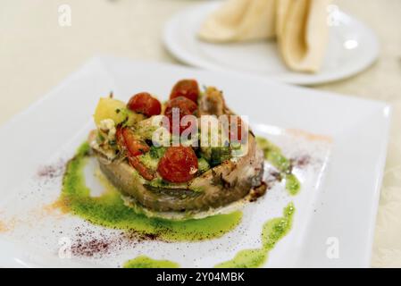 Pesce al forno con patate e pomodori Foto Stock