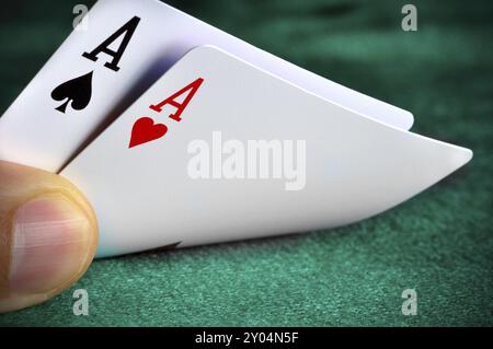 Un uomo giocando a poker e controllare le sue carte Foto Stock