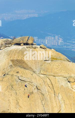 Scalatori che scalano il picco Insubong nel monte Bukhansan con vista sulla valle sottostante a Seoul, Corea del Sud, Asia Foto Stock