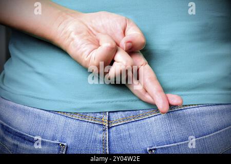 In prossimità delle dita incrociate dietro una donna di back Foto Stock