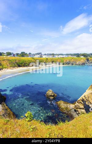 Bella Baia Azzurra sotto le scogliere vicino alla strada principale su un cielo blu giorno in Mendocino comunità in California. In verticale Foto Stock