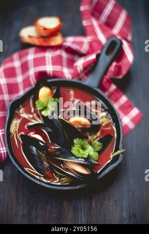 Vista dall'alto di una deliziosa zuppa con gamberi e cozze poste vicino al tovagliolo sul tavolo del ristorante Foto Stock