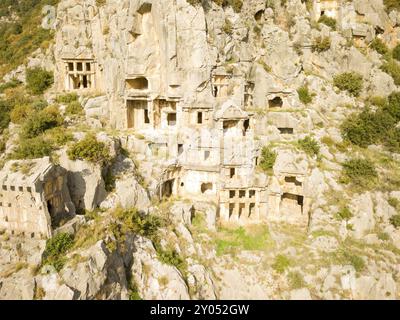 Vista a droni ad alto angolo delle tombe scavate nella roccia scolpite in una parete rocciosa a Myra, Turchia, Asia Foto Stock