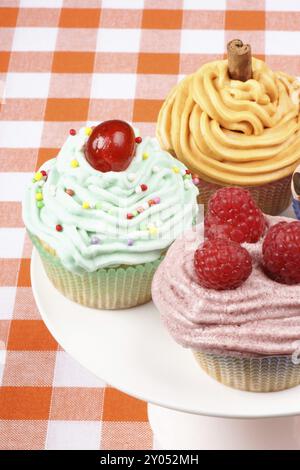 Assortimento di tortini di fantasia su una porcellana bianca cakestand Foto Stock