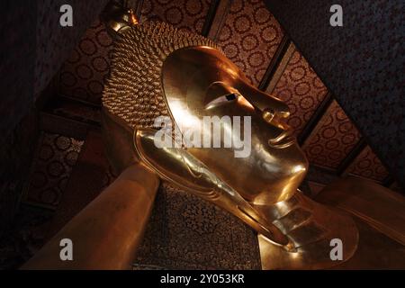 Vista interna all'interno del tempio di Wat Phra Chetuphon Wimon Mangkhalaram Rajwaramahawihan, dettaglio selettivo della statua di buddha in posa addormentata. Foto Stock