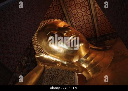 Vista interna all'interno del tempio di Wat Phra Chetuphon Wimon Mangkhalaram Rajwaramahawihan, dettaglio selettivo della statua di buddha in posa addormentata. Foto Stock
