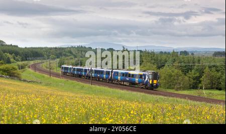 Treno elettrico multiunità ScotRail Siemens classe 385 che passa per la campagna di Auchengray, Scozia, Regno Unito Foto Stock