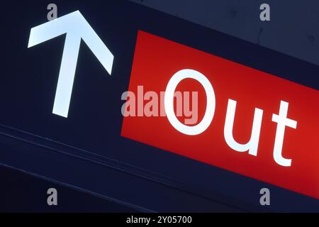 Cartello di uscita rosso con freccia bianca rivolta verso l'alto, illuminato in un ambiente buio, aeroporto di Toronto, Ontario, Canada, Nord America Foto Stock