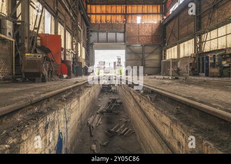 Vecchia officina abbandonata con rotaie al centro, numerosi attrezzi e pareti arrugginite, acciaierie HF4, Lost Place, Dampremy, Charleroi, provincia di Hainaut, Foto Stock