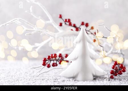 Natale o Capodanno greeting card white ramo di albero con red holly bacche ornamento di ceramica sulla neve spazio copia Foto Stock