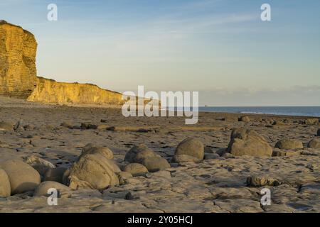 Le pietre e le scogliere di Llantwit Major spiaggia la sera sun, South Glamorgan, Wales, Regno Unito Foto Stock