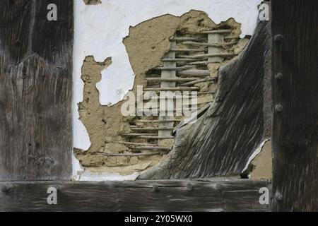 Questa sezione danneggiata di un muro in legno mostra molto bene come sono stati riempiti i compartimenti di una struttura in legno Foto Stock