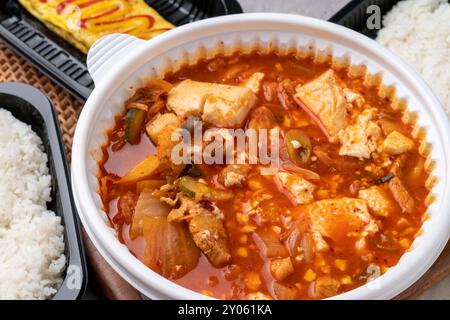 Cucina coreana, stufato kimchi, prosciutto, tofu morbido, maiale, involtino d'uovo, riso, contorni Foto Stock