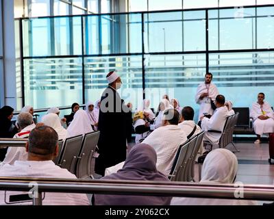 Cairo, Egitto, 3 giugno 2024: Il predicatore islamico Imam esegue Khutbah (sermone) per i pellegrini con abbigliamento Ihram all'aeroporto internazionale del Cairo prima della partenza Foto Stock