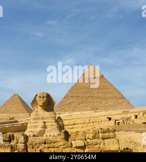 La parte anteriore rivolta verso la sfinge e le grandi piramidi egiziane di Khafre Menkaure, leggermente sfalsato nella parte anteriore del cielo blu in Giza, Cairo, Egitto. Un sacco di spazio di copia Foto Stock