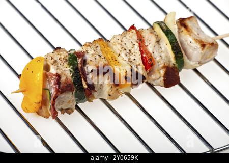 Shashlik grigliato su una griglia di carbone su sfondo bianco Foto Stock