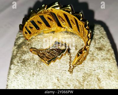 Bracciale in oro rotto, gioielli o gioielli, oggetti decorativi indossati per ornamenti personali, un articolo di gioielli che viene indossato intorno al polso, Decre Foto Stock