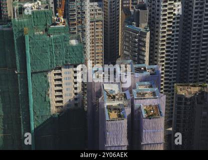 Cantiere con impalcature in bambù. Giardini sul tetto. Scena nel centro di Hong Kong. Architettura densa Foto Stock