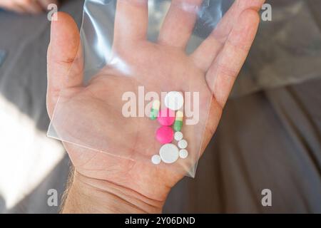 Donna che regge pillole. Primo piano delle pillole in un imballaggio senza faccia. Pillole e integratori alimentari nelle dita femminili in un contenitore Foto Stock