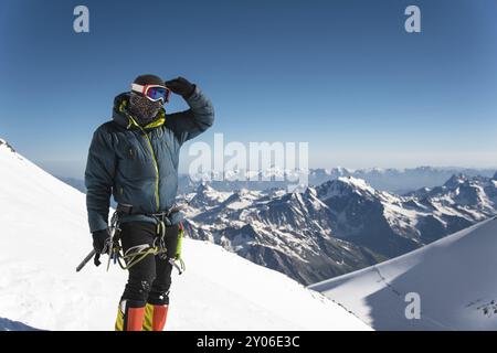 Guida professionista completamente attrezzata, arrampicatore sulla cima innevata del vulcano Elbrus addormentato Foto Stock