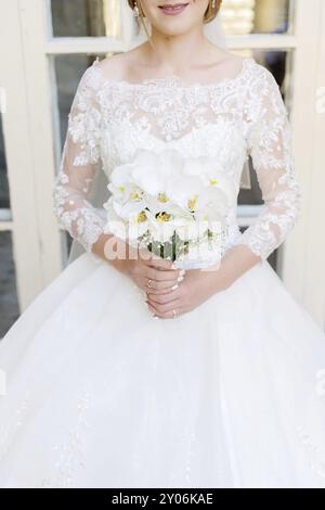 Primo piano di una sposa che tiene un bouquet di nozze. Il concetto di un festival di nozze e di una vita felice Foto Stock