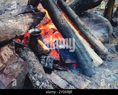 Preparare il caffè in un turco su un fuoco aperto. Foto Stock