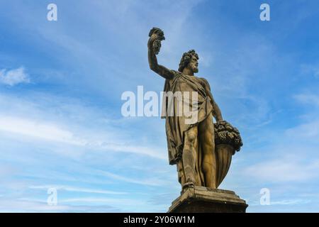 Vista dall'angolo basso della statua "Autunno" di Giovanni Battista Caccini, situata sul ponte storico di Ponte Santa Trinita, Firenze, Toscana, Italia Foto Stock