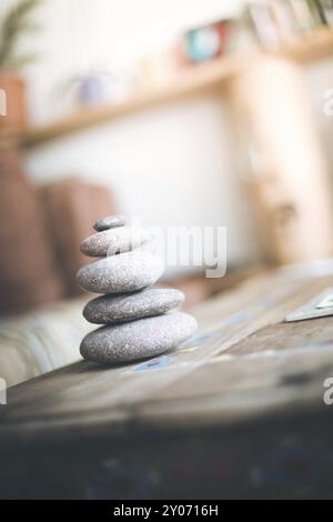 Feng Shui: Cairn di pietra in primo piano, salotto sfocato sullo sfondo. Equilibrio e relax Foto Stock