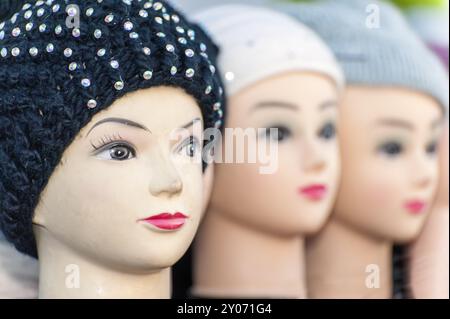 3 teste di bambola una accanto all'altra con cappelli a maglia Foto Stock