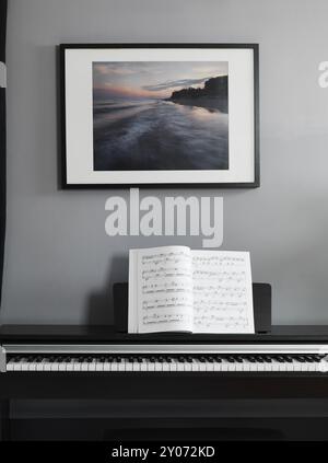 Pianoforte digitale tastiera con spartiti in una sala interna Foto Stock