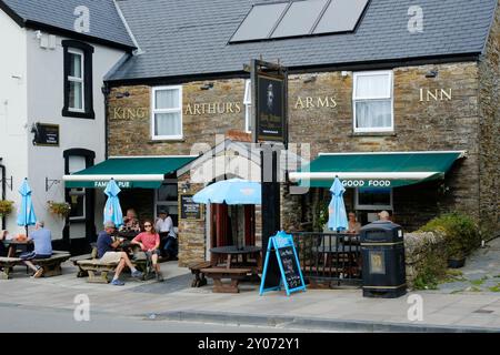 Visitatori che mangiano e bevono fuori King Arthur's Arms, Tintagel, Cornovaglia, Regno Unito - John Gollop Foto Stock