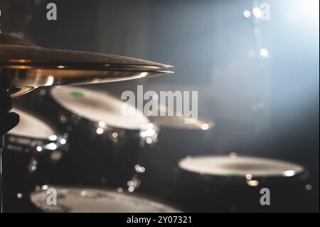 Primo piano tamburo in una stanza buia contro lo sfondo del riflettore. Sfondo atmosferico simbolo della musica rock o jazz. Piastre in rame su Foto Stock