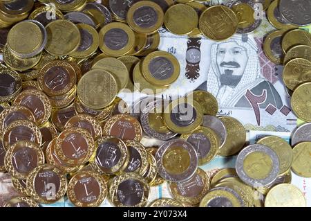 Monete di riyal saudita, 2, 1, mezza e un quarto di moneta su banconote in denaro saudita di riyal banconote, di diversi valori, moneta ed economia Foto Stock