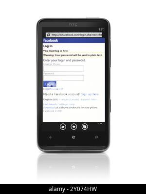 Telefono Windows 7. Smartphone HTC HD7 con pagina di accesso Facebook sul display isolato con percorso di ritaglio su sfondo bianco. Foto di alta qualità Foto Stock