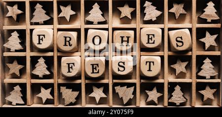 Scatola di legno con le parole tedesche Buon Natale e albero di piccole dimensioni e forme a stella Foto Stock