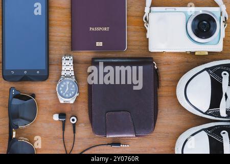 Sfondo di viaggio con oggetti fotografici, passaporto, portafoglio, orologi, cuffie, scarpe, occhiali da sole, smartphone Foto Stock