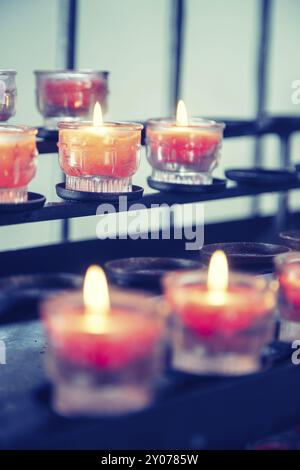 Primo piano di candele nella vecchia chiesa cattolica, sfondo sfocato Foto Stock