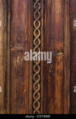 Sfondo vintage. Elementi di una vecchia porta in legno intagliato decorati con voluminosi elementi in legno intagliato che imitano la tessitura. Un concetto vintage di Foto Stock