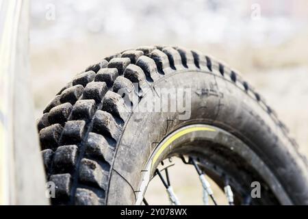 Protezione di una ruota per motociclette per guida fuoristrada enduro e prova. Un primo piano di gomma per motociclette estreme. Il concetto di sport motoristico t Foto Stock