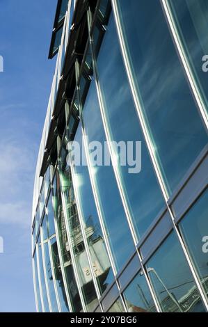 Riflesso di una gru nella finestra di fronte a un edificio di uffici Foto Stock