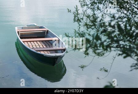 Barca a remi sul lago calmo con riflessione Foto Stock