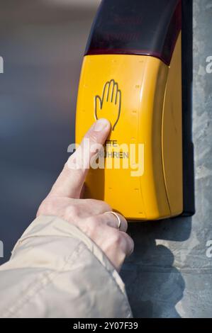 Dito indice allungato sul pulsante di un sistema a semaforo Foto Stock