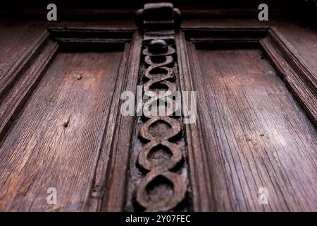 Sfondo vintage. Elementi di una vecchia porta in legno intagliato decorati con voluminosi elementi in legno intagliato che imitano la tessitura. Un concetto vintage di Foto Stock